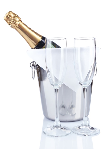 Bottle of champagne in pail and empty glasses isolated  