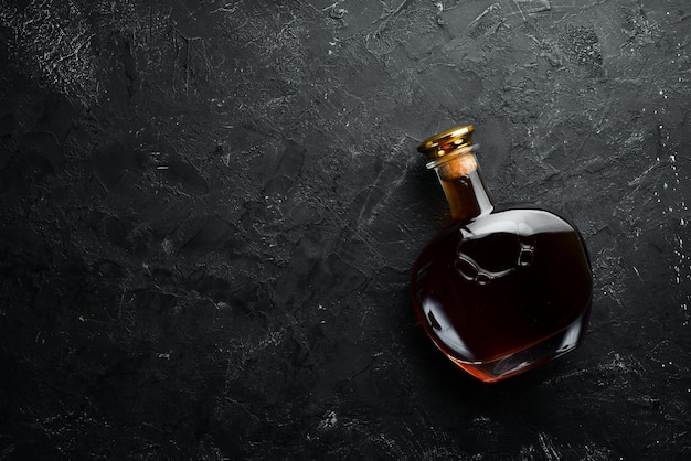 A bottle of cognac on a black background Top view Free space for your text