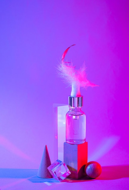 Bottle of cosmetic serum in neon light