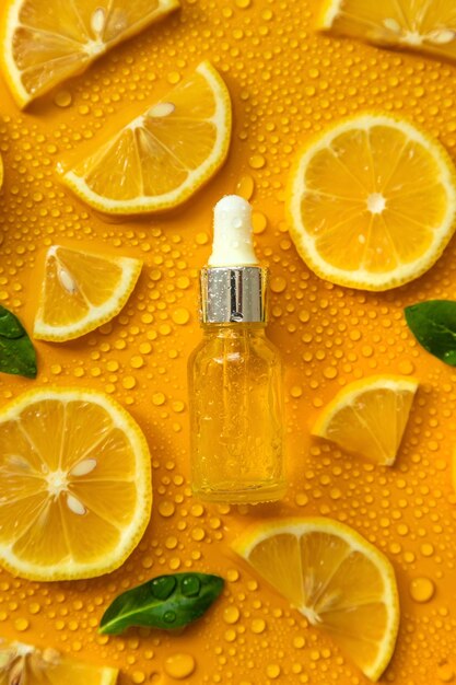 Bottle of cosmetics and drops of liquid moisturizing lemon Hyaluronic acid Selective focus