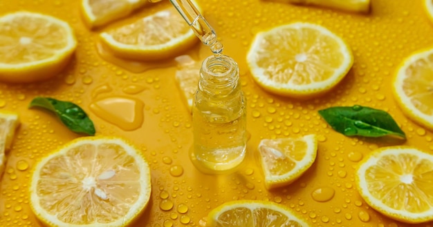 Bottle of cosmetics and drops of liquid moisturizing lemon Hyaluronic acid Selective focus