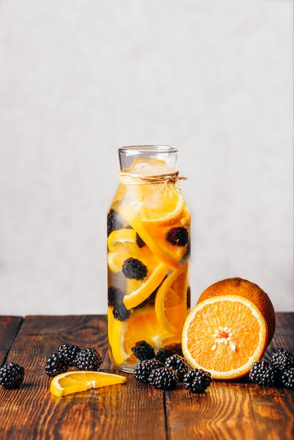 Bottle of Detox Water Infused with Sliced Raw Orange and Fresh Blackberry