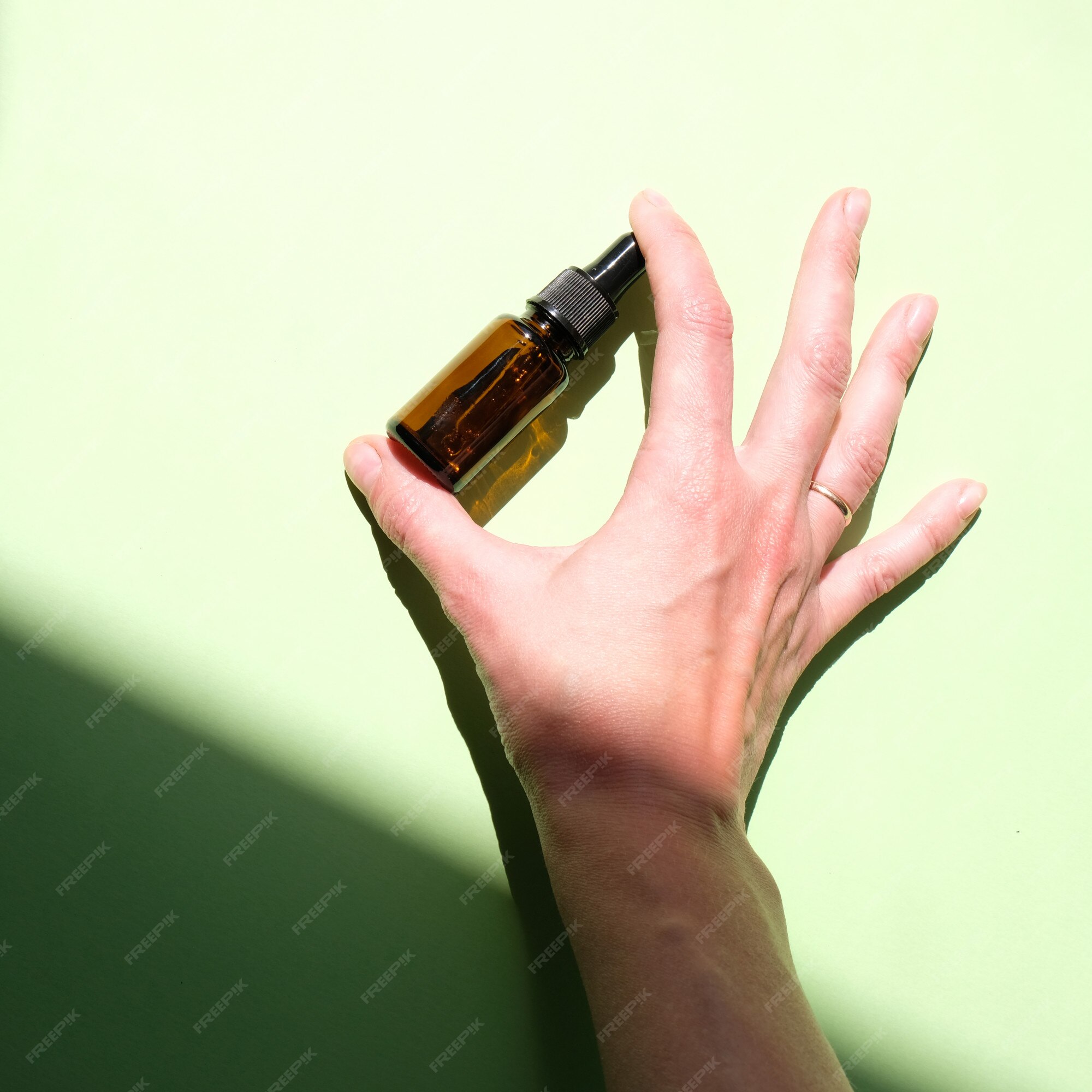 Premium Photo | Bottle of essential oil in hand