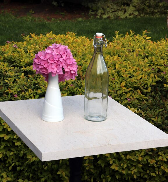 Bottle and flower in vase in the marble table