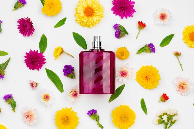 Photo bottle of fragrance surrounded by flower buds close up