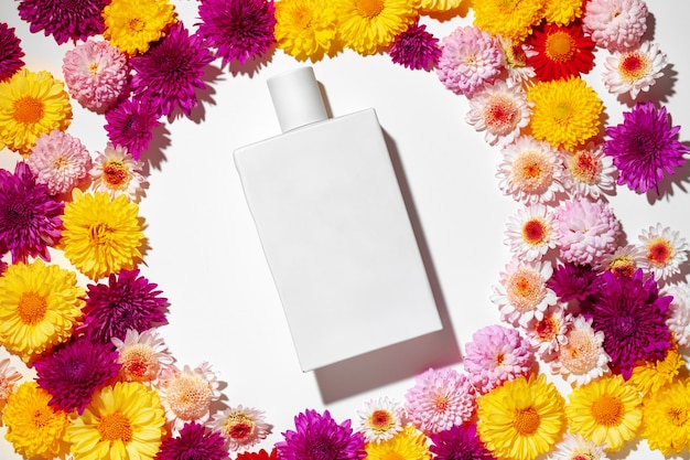 Photo bottle of fragrance surrounded by flower buds close up