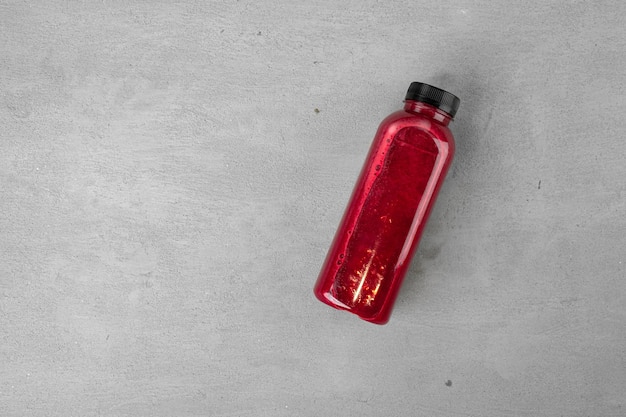 Bottle of fresh beet juice on gray background close up