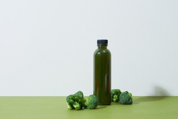 Bottle of the fresh broccoli juice on table. Healthy drink.