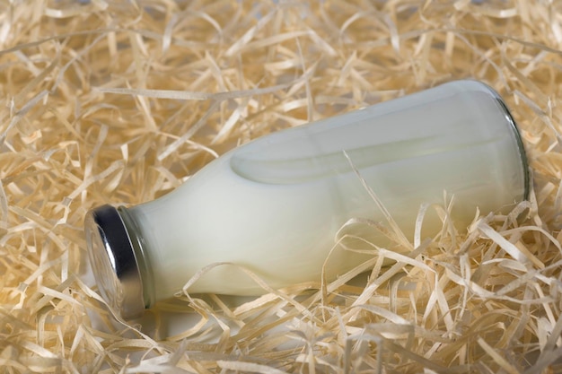 Bottle of fresh milk in the hay closeup Healthy food