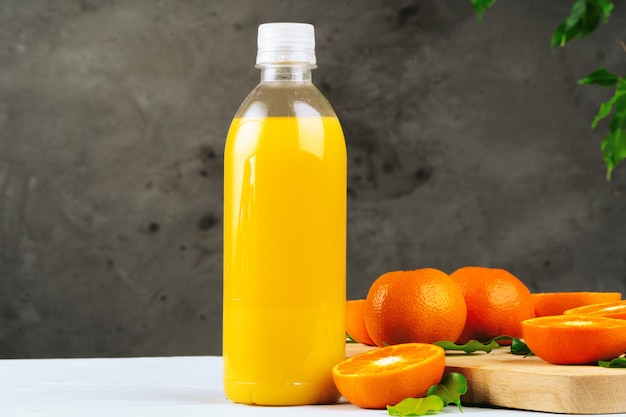 Bottle of fresh orange juice on wooden table