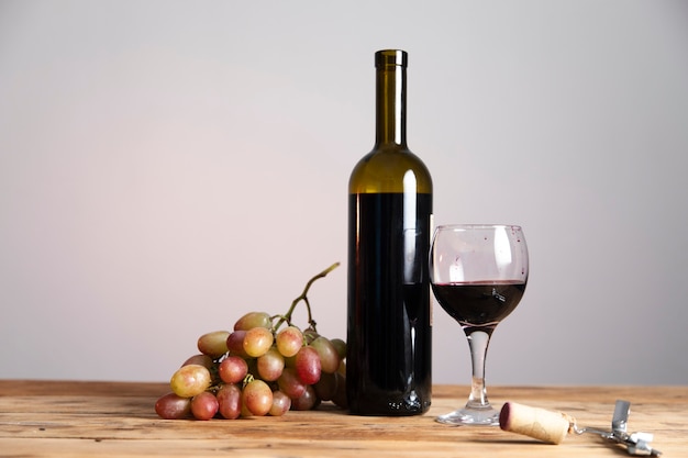 Bottle and glass of Red wine with ripe grapes