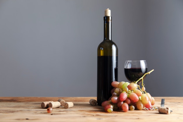 Bottle and glass of Red wine with ripe grapes