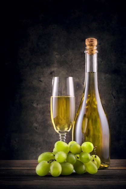 Bottle and glass of white wine with grapes