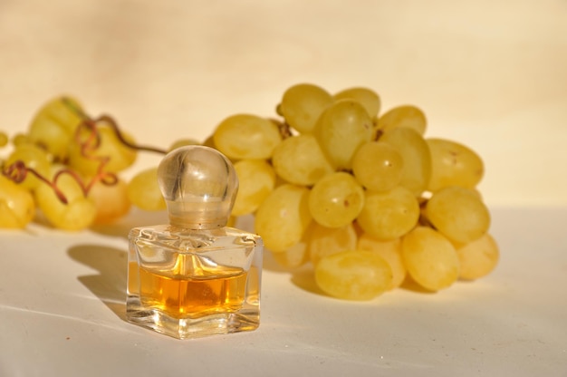 Bottle of grape seed oil next to a bunch of grapes