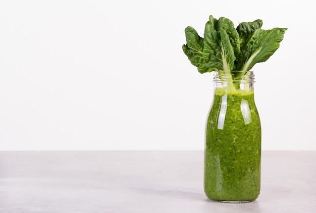 Bottle of green smoothie with kale and chlorophyll copy space