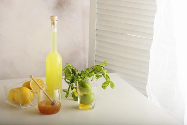 Bottle of homemade juice with ginger and lemon on light background Horizontal