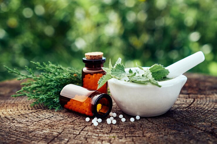 Photo bottle of homeopathic globules mortar of green nettle and mint leaves juniper twigs homeopathy