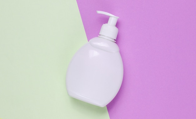 Bottle of liquid soap on a two-ton paper background. Shower gel, shampoo. Top view