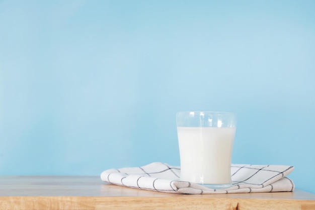 bottle of milk and a glass on wooden table.