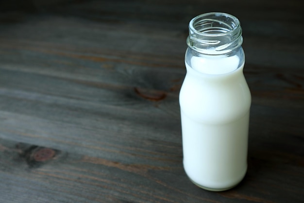 A Bottle of milk isolated on black wooden background