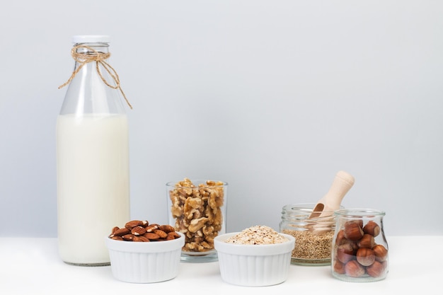 A bottle of milk and nuts in jars and bowls