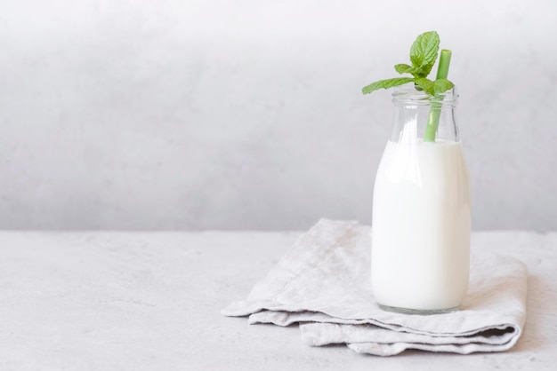 Foto bottiglia di latte e foglie di menta piperita