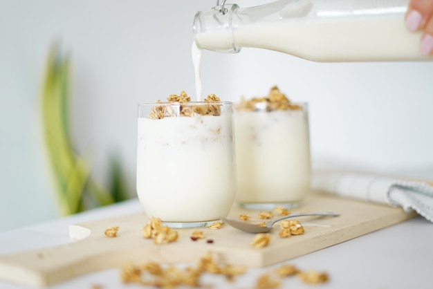 Photo a bottle of milk pouring into a glass filled with oats