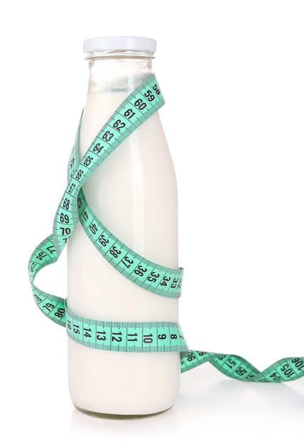 Bottle of milk with measuring tape isolated on white