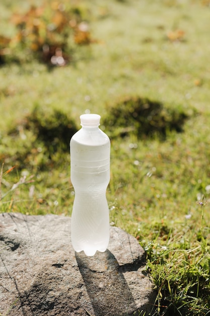 Bottle of mineral water on nature background, summer day