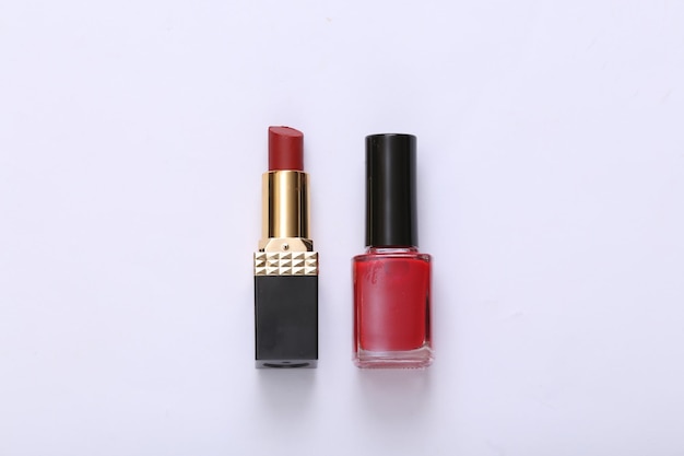 Bottle of nail polish and lipstick on white background