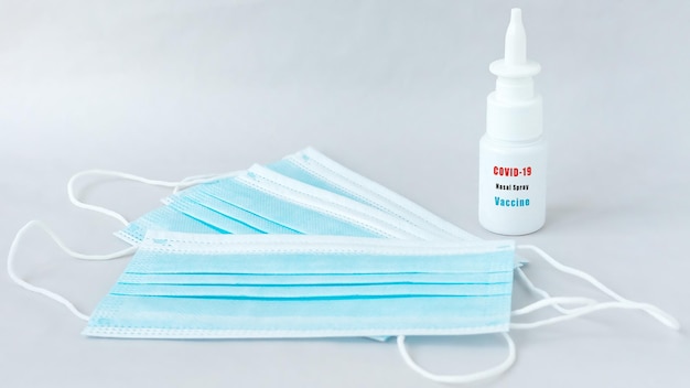 A bottle of nasal spry against covid with surgical masks