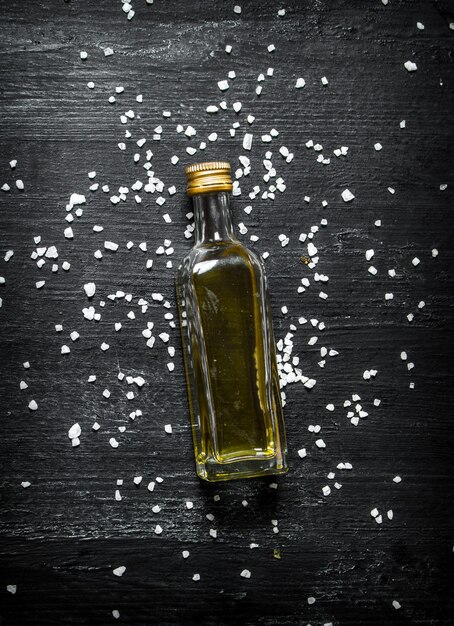 bottle of olive oil. on black rustic background.