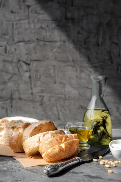 Foto bottiglia di olio d'oliva con pane fresco sul tavolo