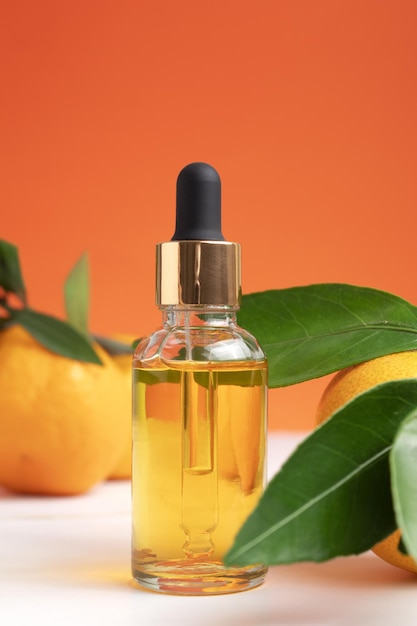 Bottle of orange essential oil for aromatherapy Orange essential oil Citrus essential oil on friut background