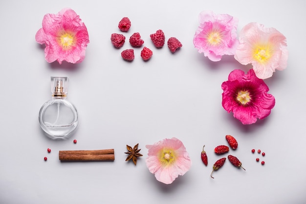 Bottle of perfume and fragrance ingredients: flowers, berries and spices. Perfume fragrance concept