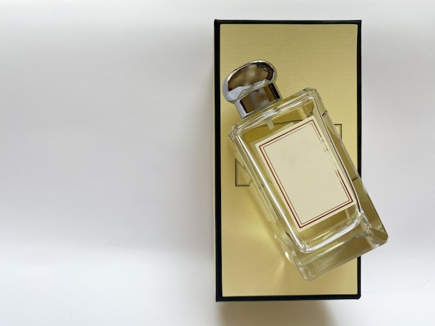 Photo a bottle of perfume from a yellow box on a white isolated background