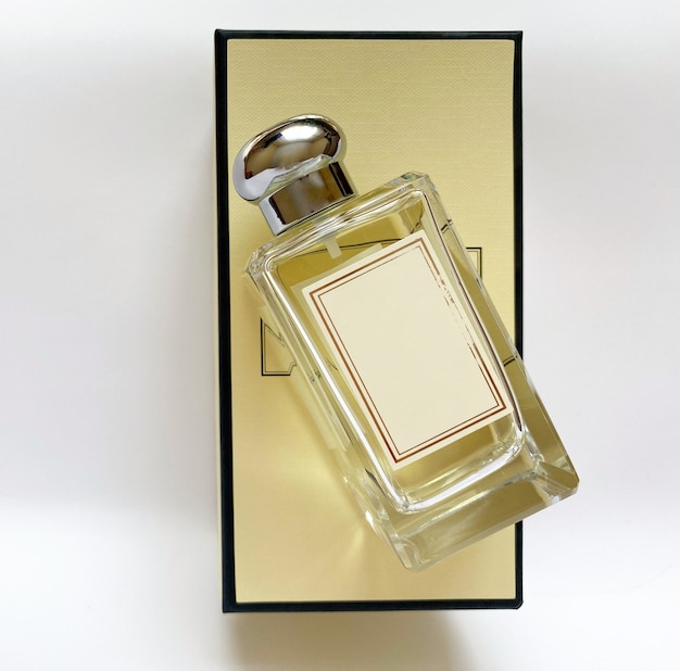 A bottle of perfume from a yellow box on a white isolated background