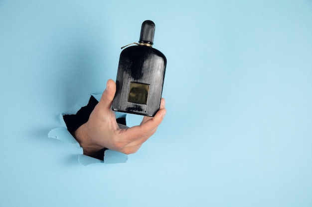 Bottle of perfume in a man hand