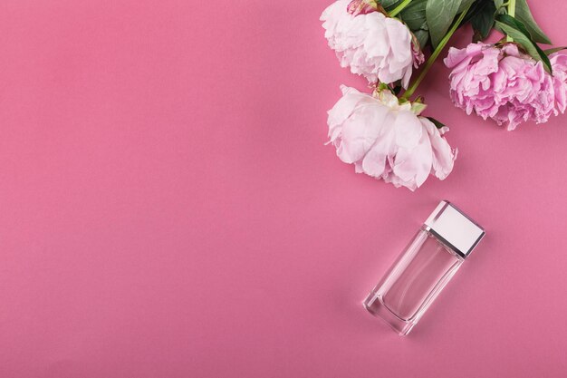 Bottle of perfume and peony flowers