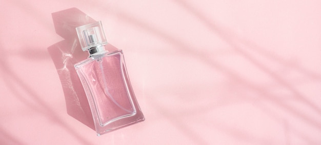 Una bottiglia di profumo su sfondo rosa