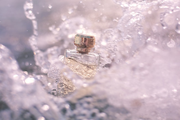 Bottle of perfume in sea foam