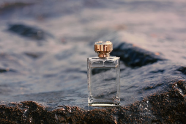 Bottle of perfume on the of the sea