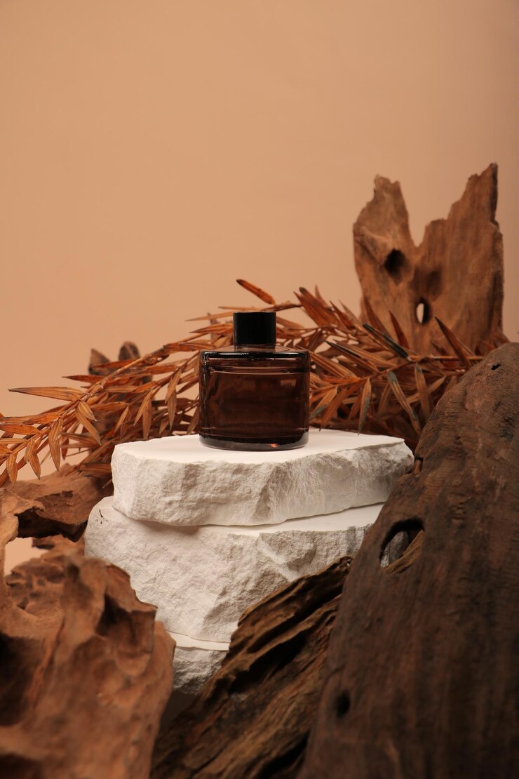 a bottle of perfume sits on a stone in front of a wall
