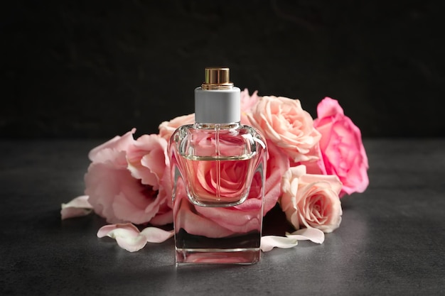 bottle of perfume with flowers on dark background
