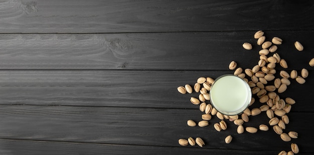 Bottle of pistachio milk on a black background with empty space for text