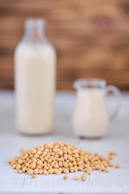 Photo bottle and pitcher of soy milk on white table