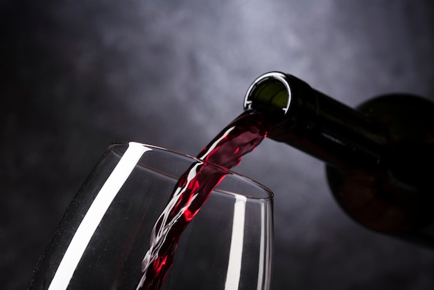 Bottle pouring red wine into glass