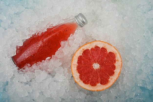 Bottle of red grapefruit drink on ice