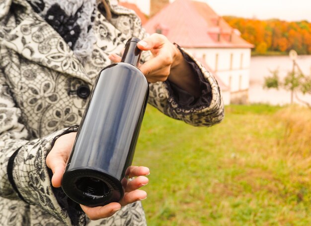 Bottle of red wine in female hands