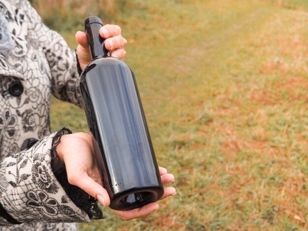 Bottle of red wine in female hands